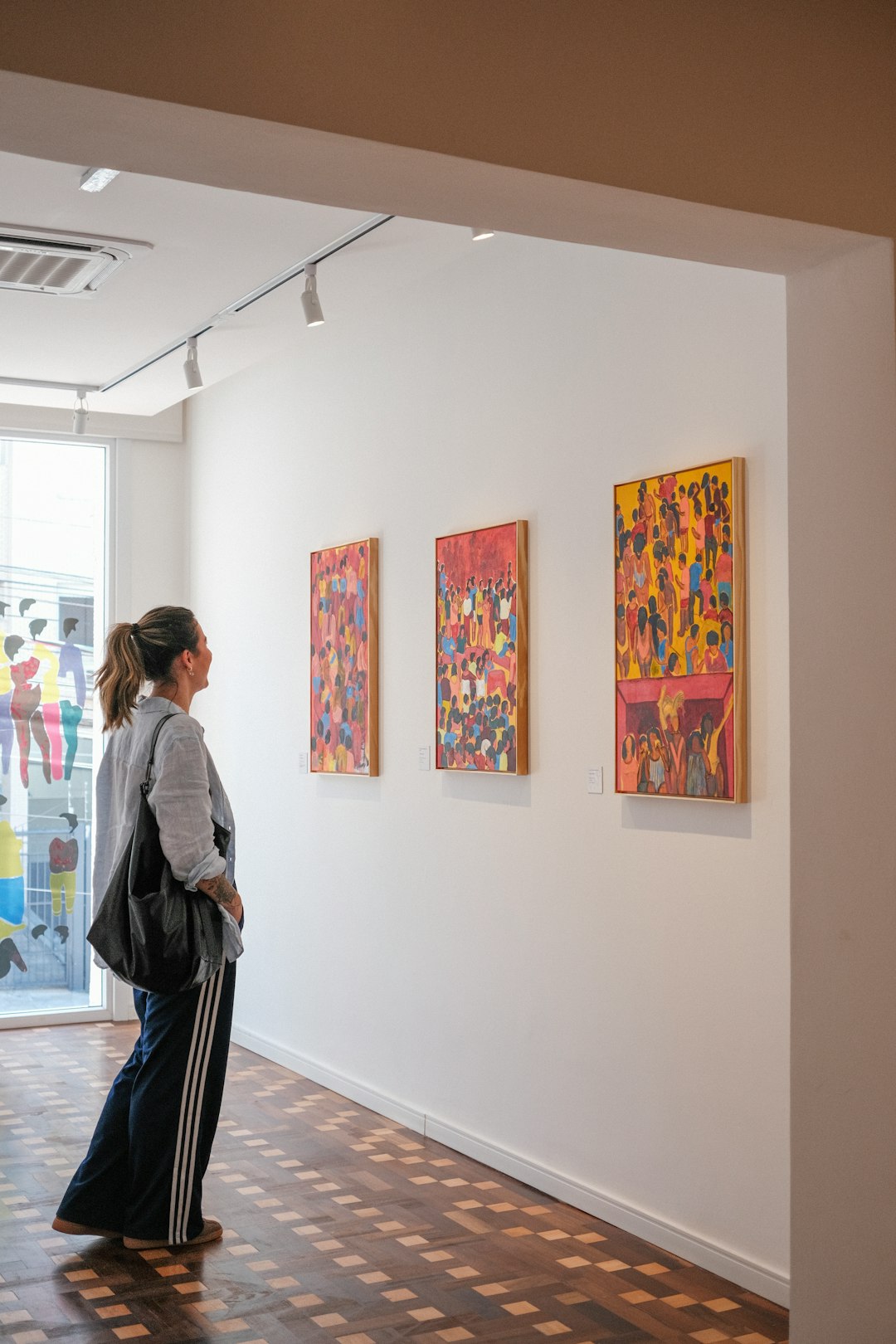 woman-observing-colorful-paintings-in-an-art-gallery-qxvomduqdsg